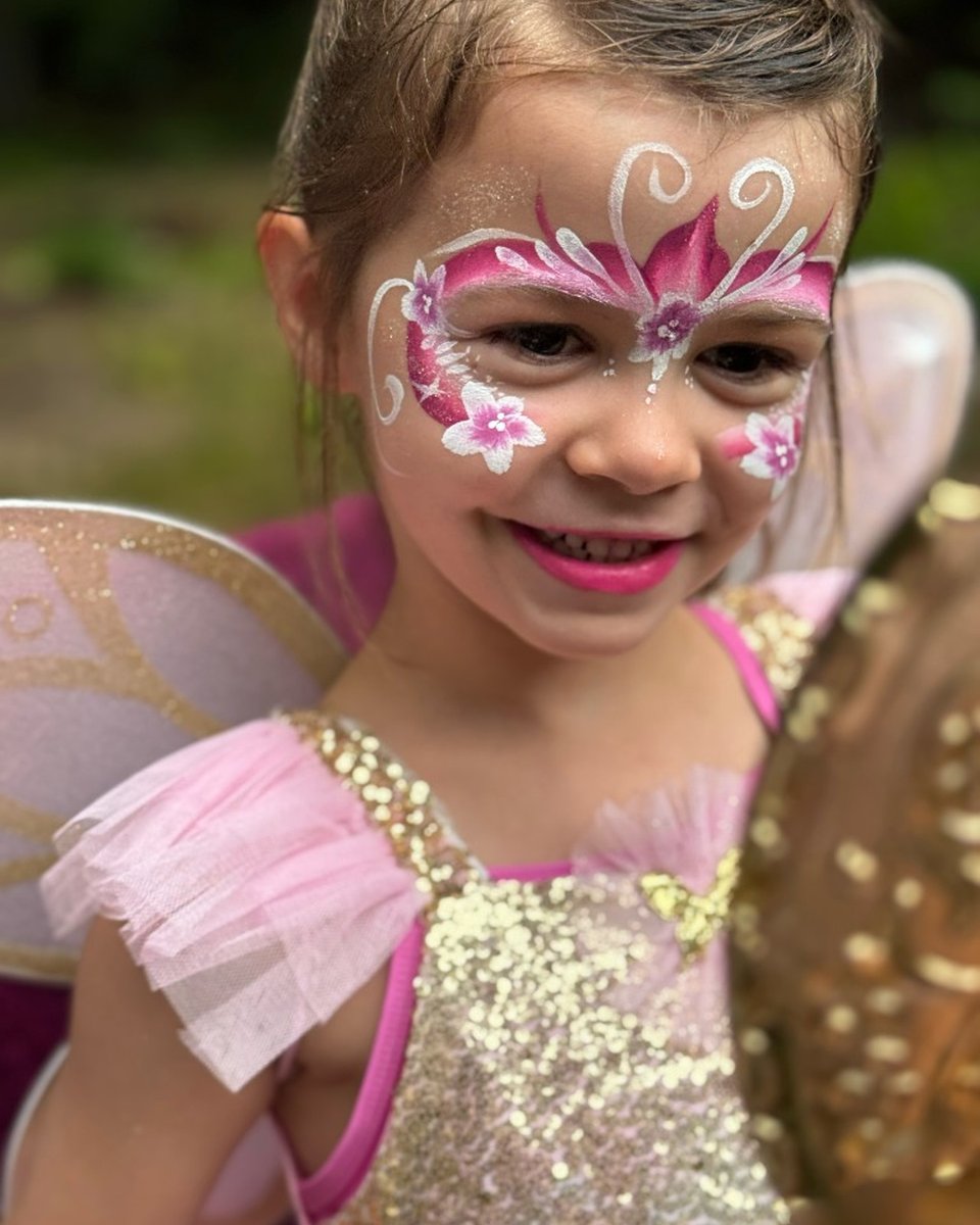 Child in fairy wings with magenta butterfly face painting by Wildflower Face Art