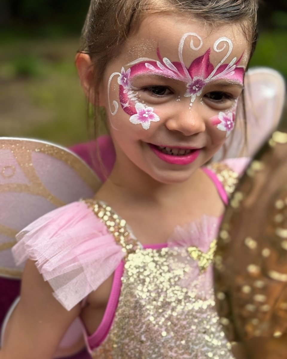 Child in fairy costume with pink butterfly face painting by Wildflower Face Art