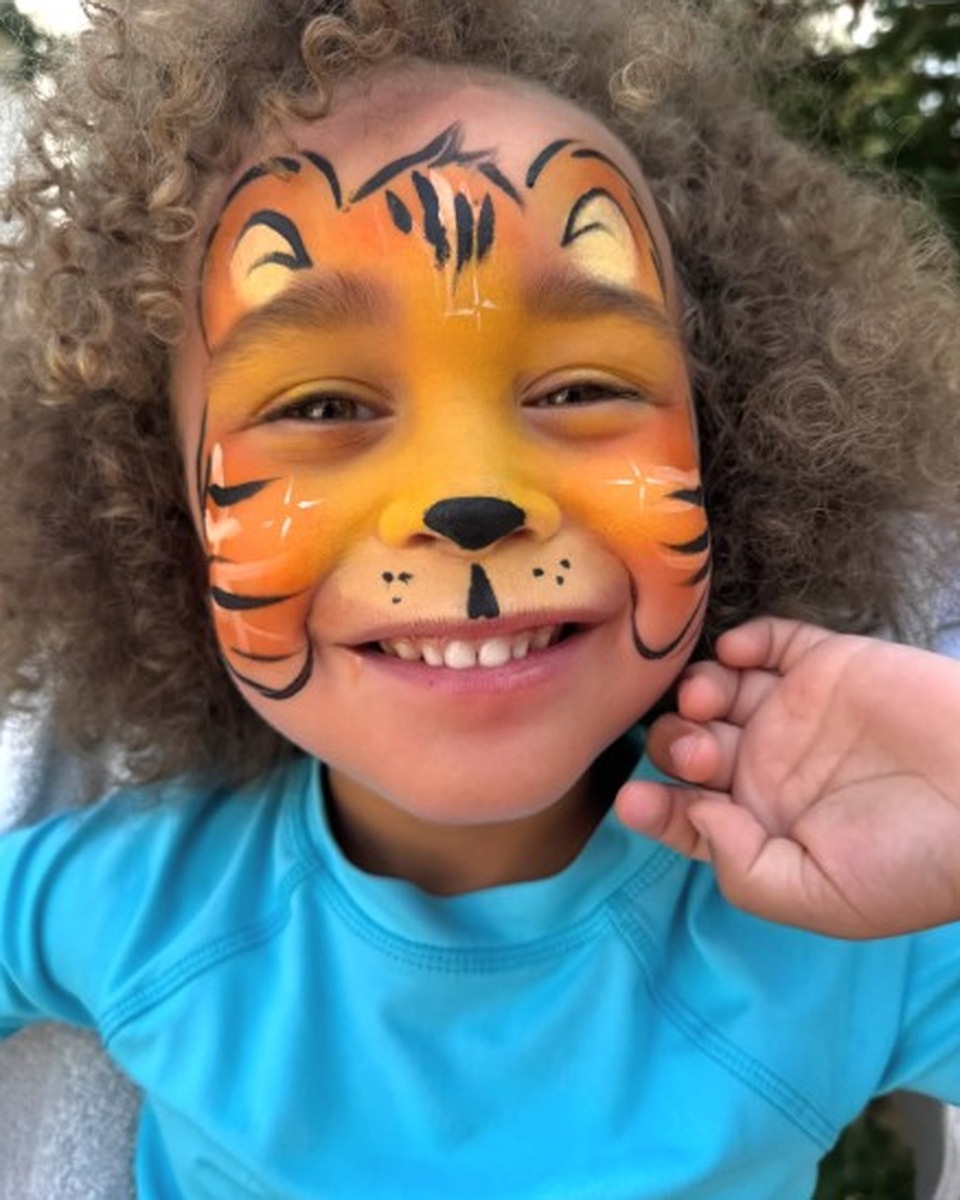 Child with tiger face painting by Wildflower Face Art