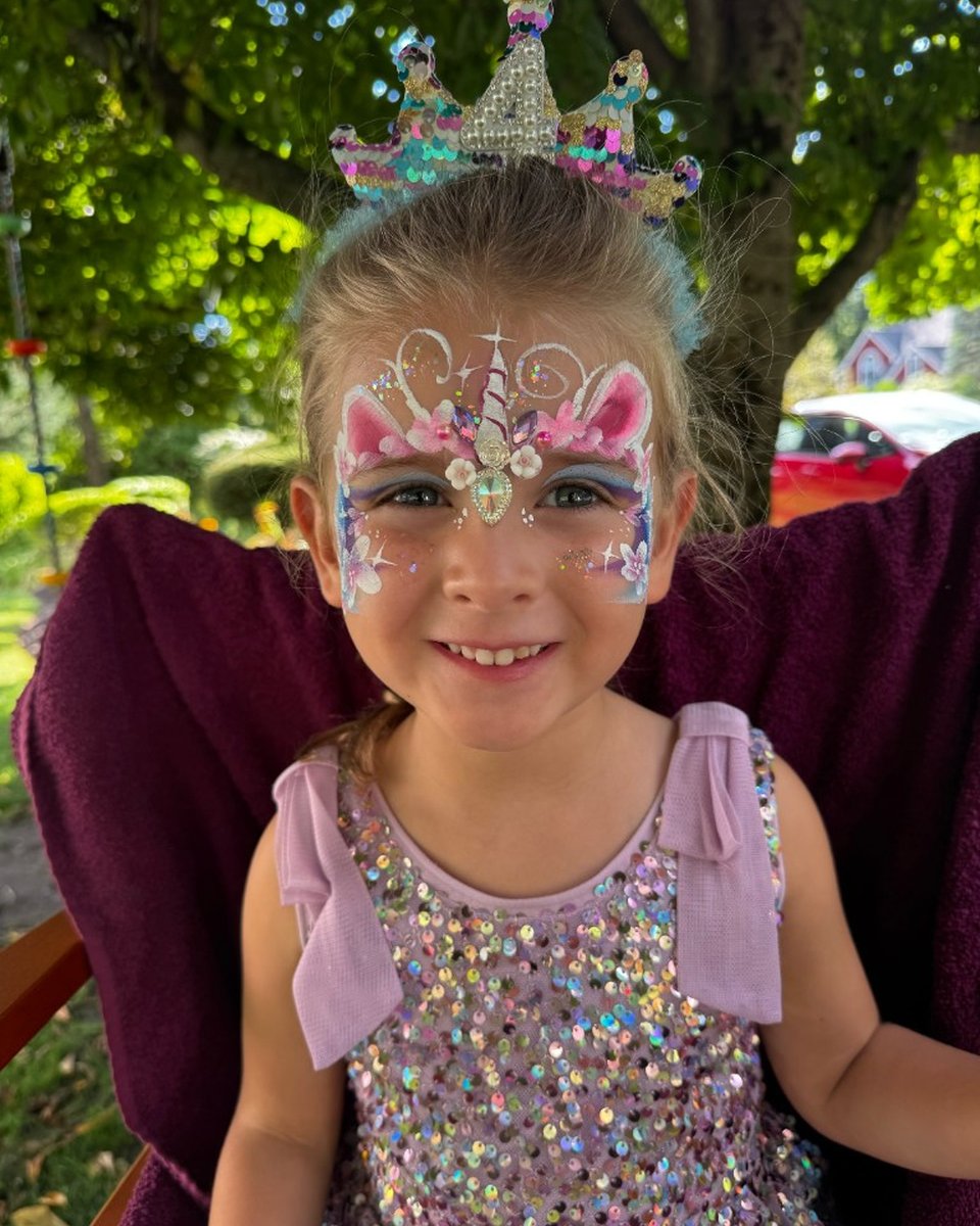 Child with unicorn face painting and birthday crown by Wildflower Face Art